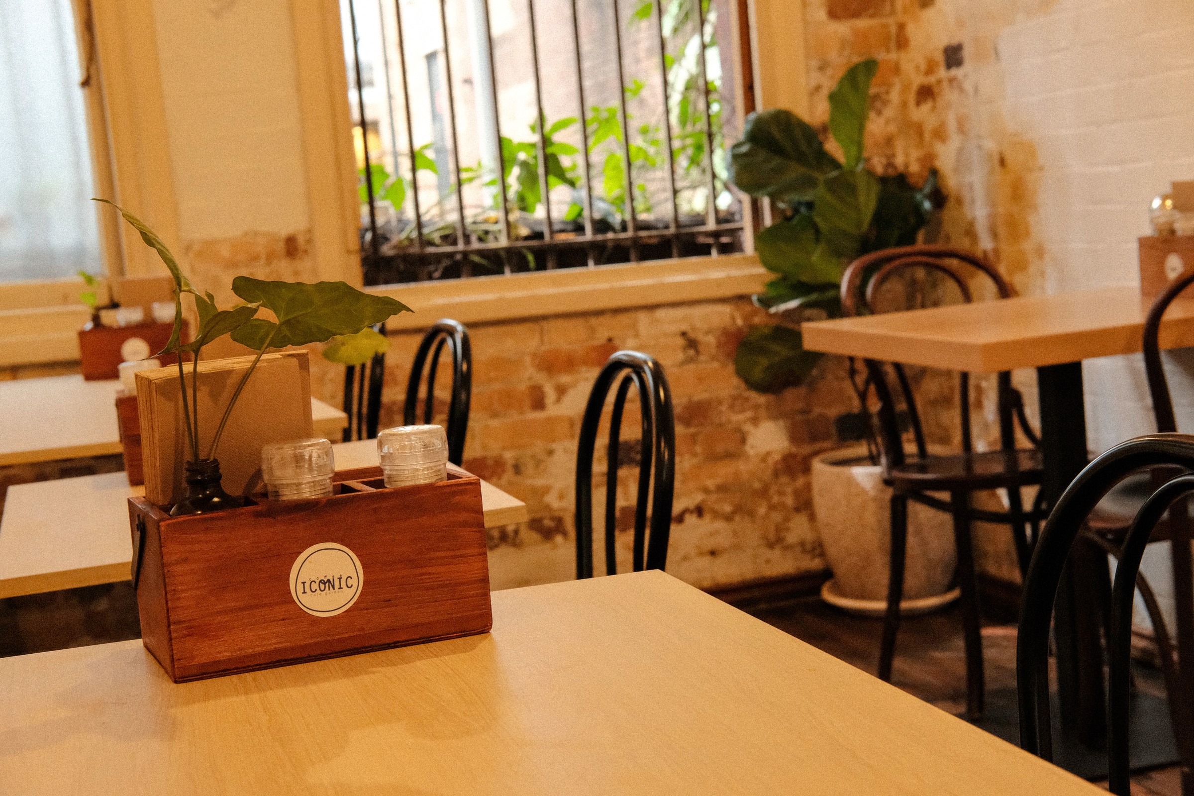 Coffee Iconic table setting, black chairs and warm brick walls