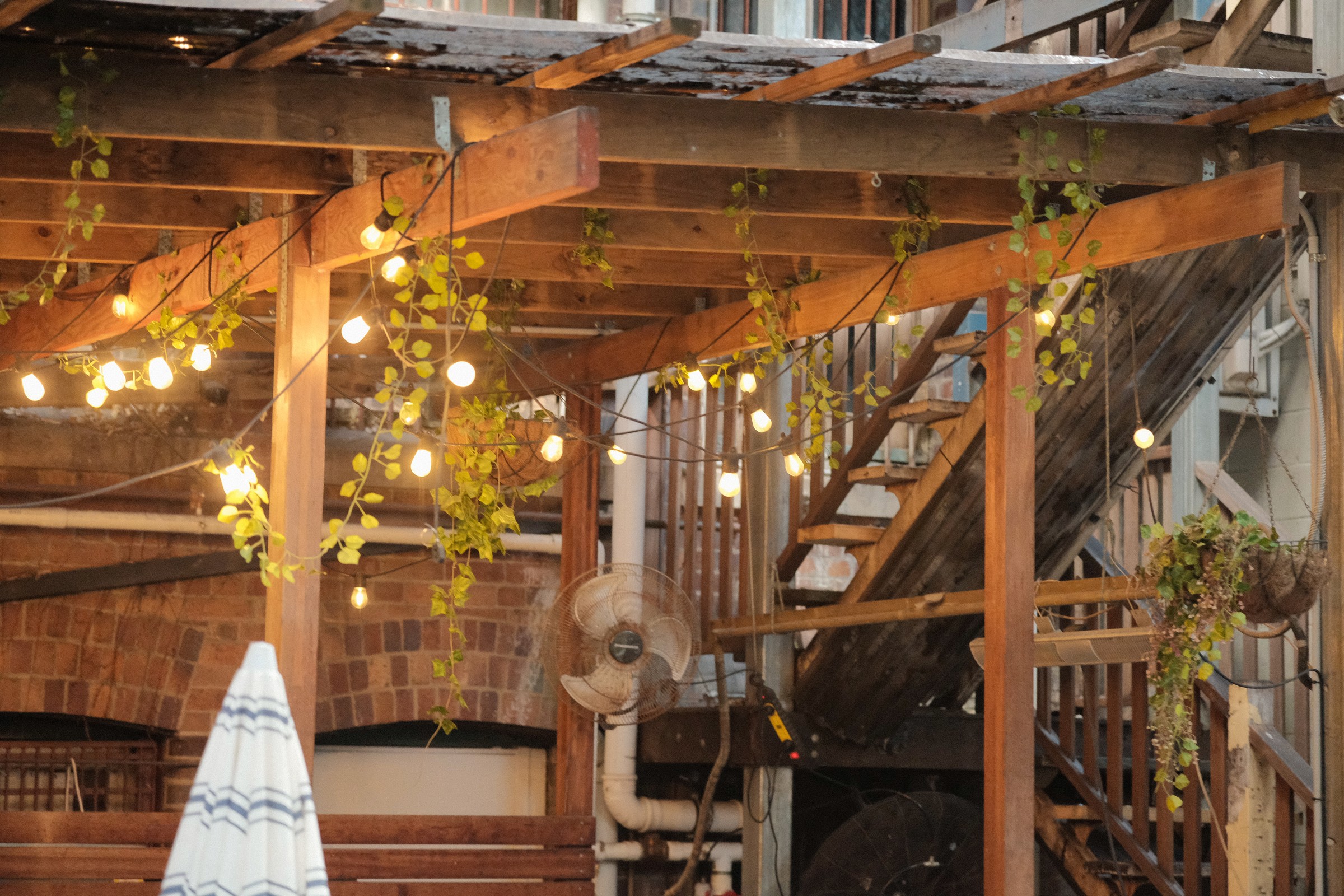Timber pergola, string lights and stairs in the café courtyard