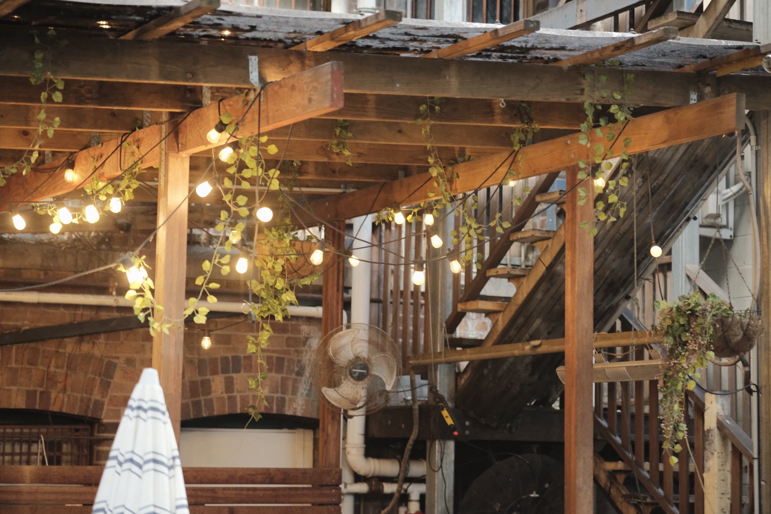 Outdoor café tables beneath the timber pergola